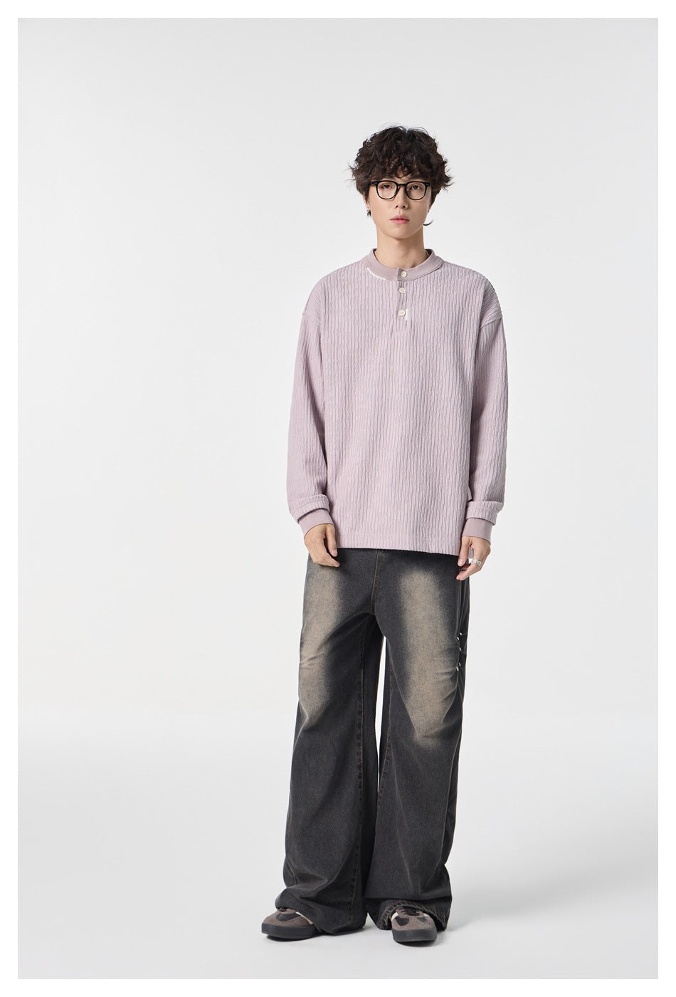 Front view of a model wearing a dusty lilac ribbed top with a stand collar, three-button placket and long sleeves.