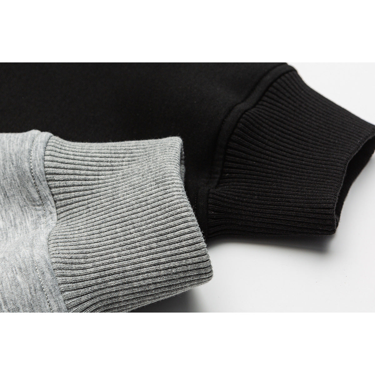 Close-up of ribbed cuffs on heather gray and black jackets.