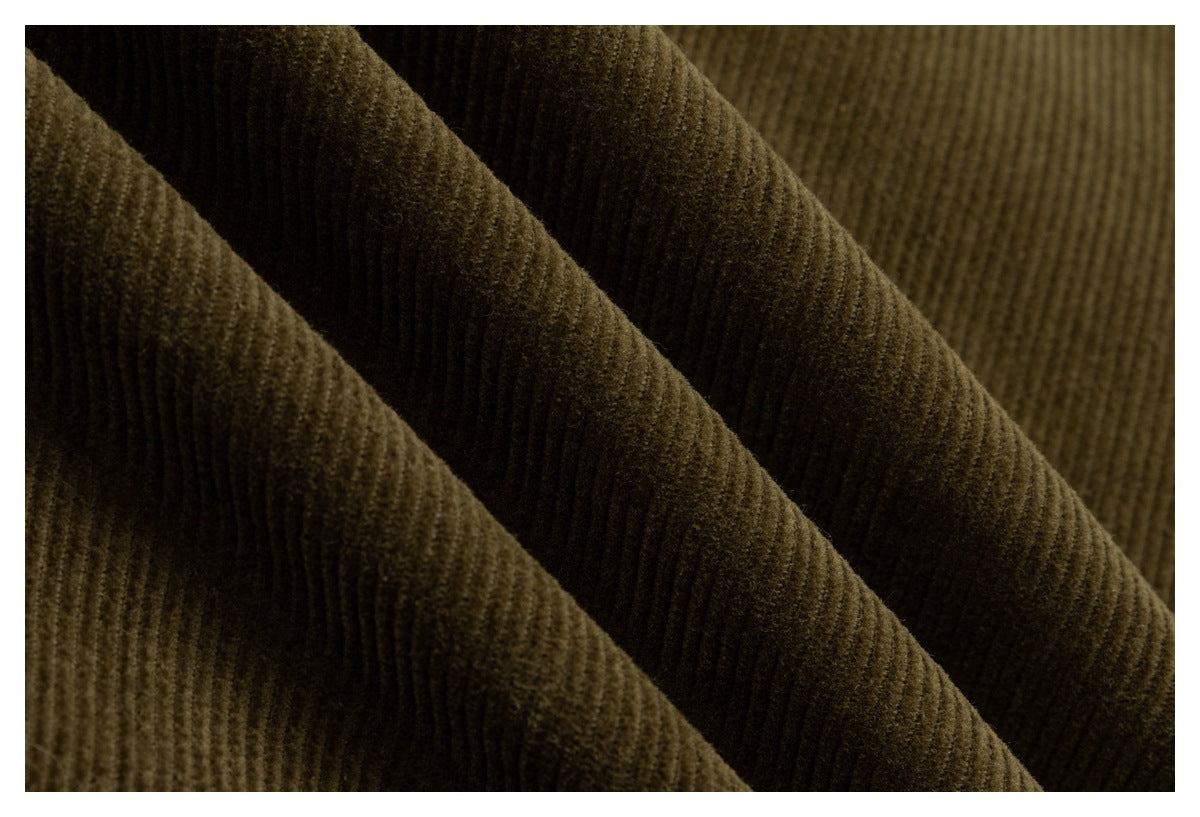Macro view of the deep olive-brown corduroy fabric’s raised parallel ribs and soft-looking texture.