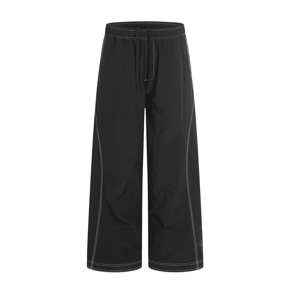 Black wide-leg pants with drawstring elastic waist and white contrast topstitching, front view on a plain background