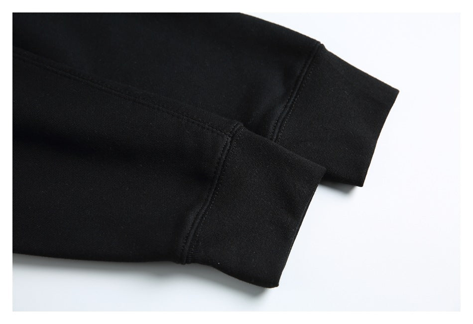 Close-up of black sweatshirt sleeves ending in wide ribbed cuffs with visible stitching.