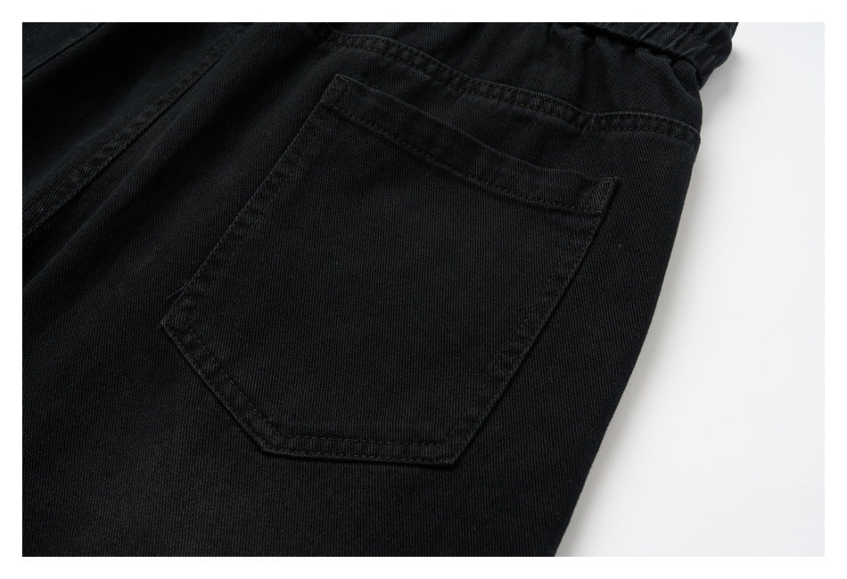 Close-up of a black trouser back pocket with dark stitching.