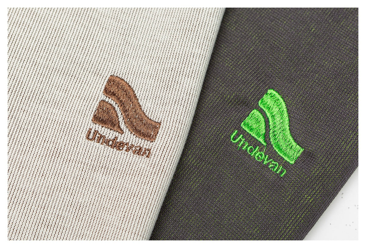 Close-up of brown and bright green embroidered emblems on cream and charcoal ribbed fabric.
