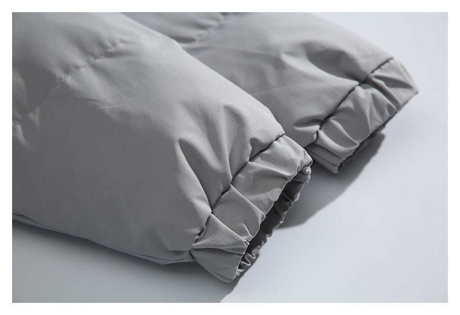 Close-up of a light gray padded jacket sleeve cuff with gathered elastic trim.