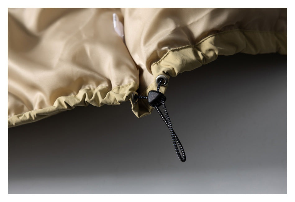 Close-up of a khaki jacket hem with a black adjustable drawcord and toggle.