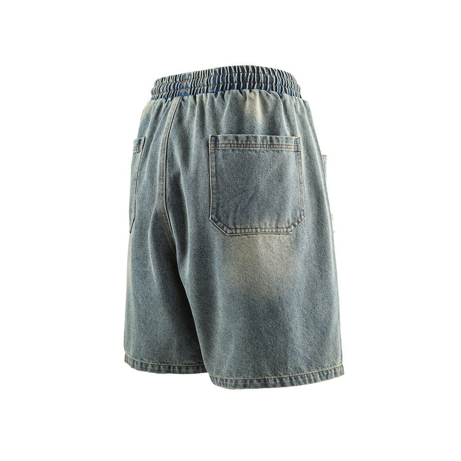 Back view of washed blue denim shorts with elastic waistband and a patch back pocket with contrast stitching