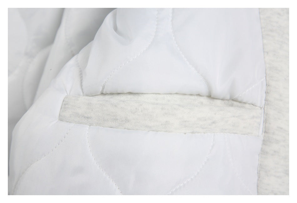 Close-up of white quilted lining with a light gray fabric insert.
