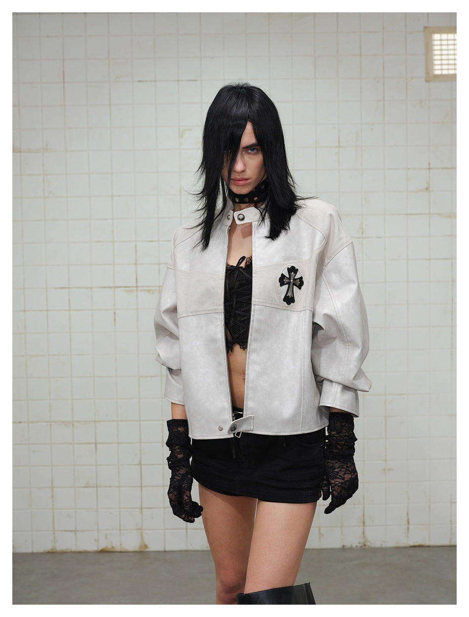 Model wearing an open light gray zip jacket with cross patch over a black lace-up top, black skirt and lace gloves