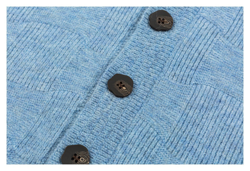 Close-up of the light blue cardigan's knitted front placket with three dark buttons.