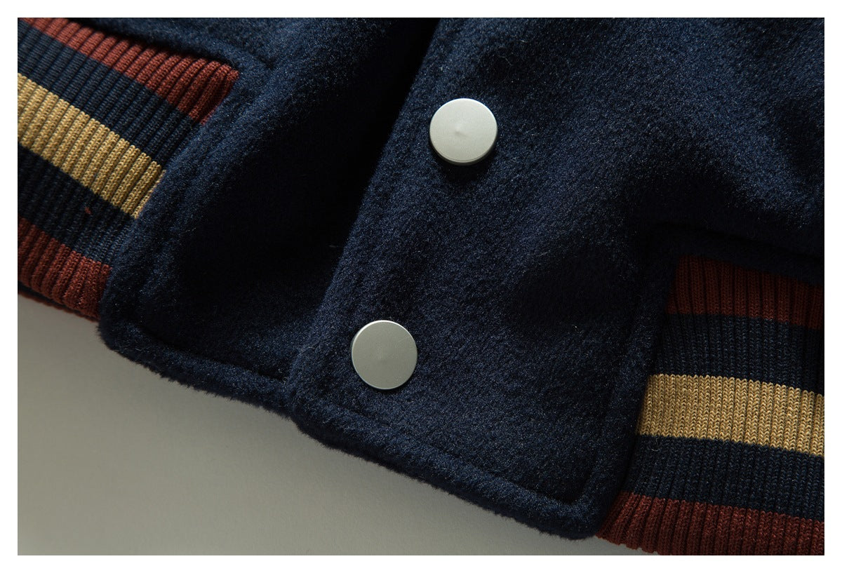 Close-up of a navy jacket front with two white snaps and rust, navy, and tan striped ribbed trim.