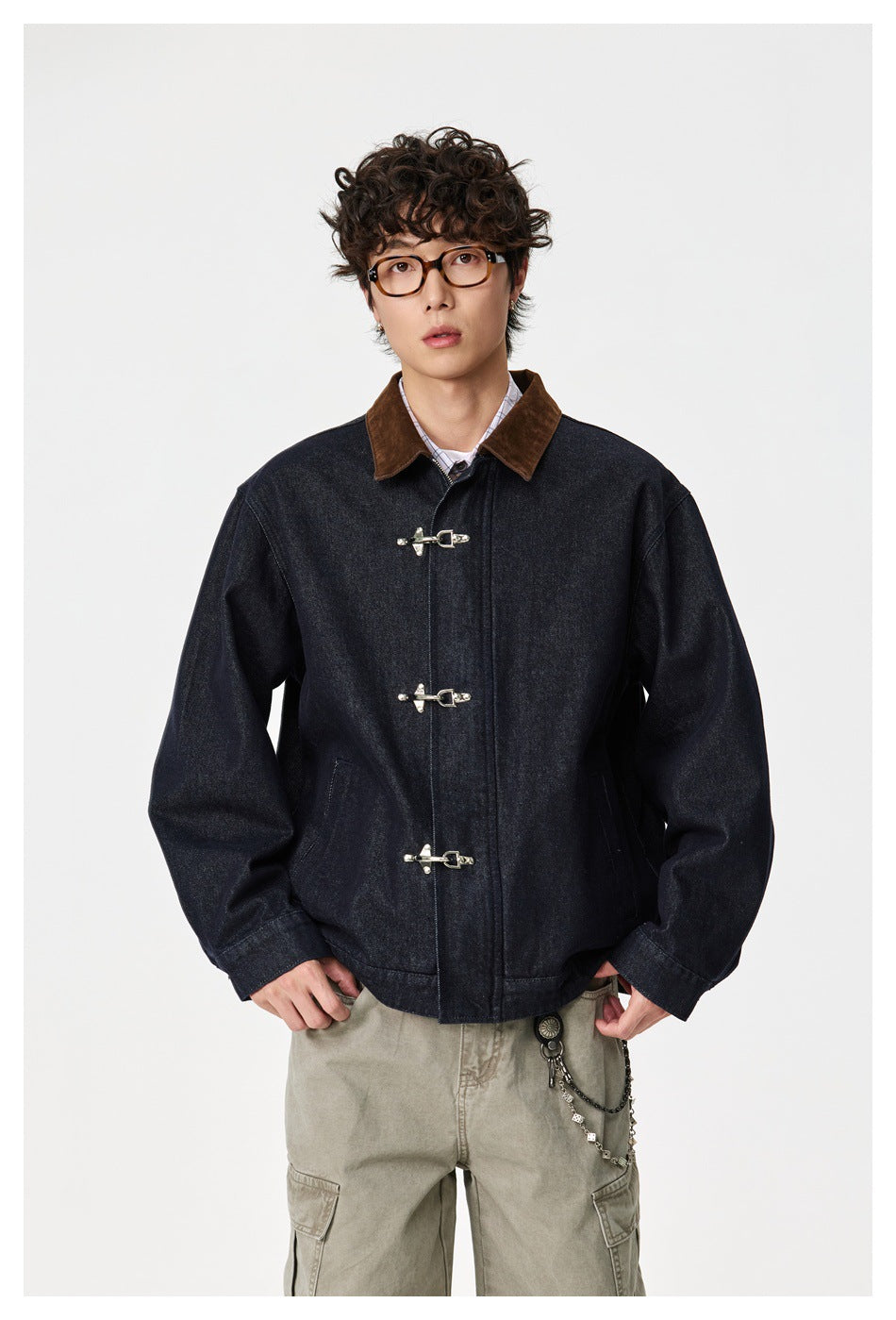 Front view of a model wearing a dark indigo jacket with a brown collar, silver toggle closures, and slanted pockets.
