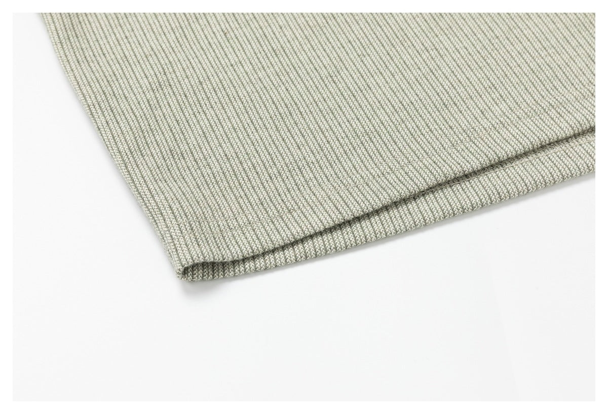 Folded edge of gray and off-white finely textured fabric against a white background.