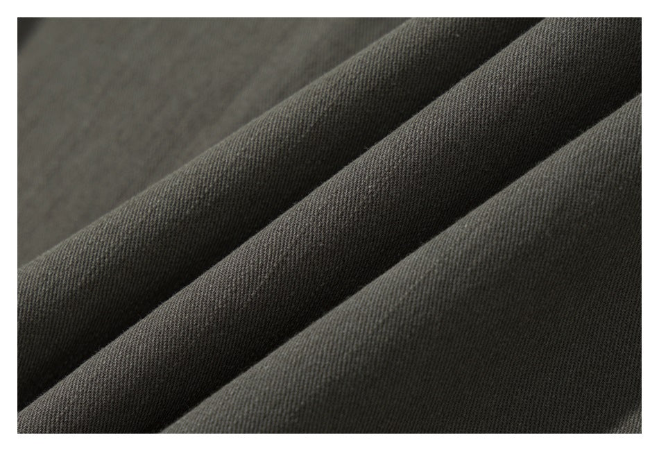 Macro view of the dark olive garment fabric draped in soft folds.