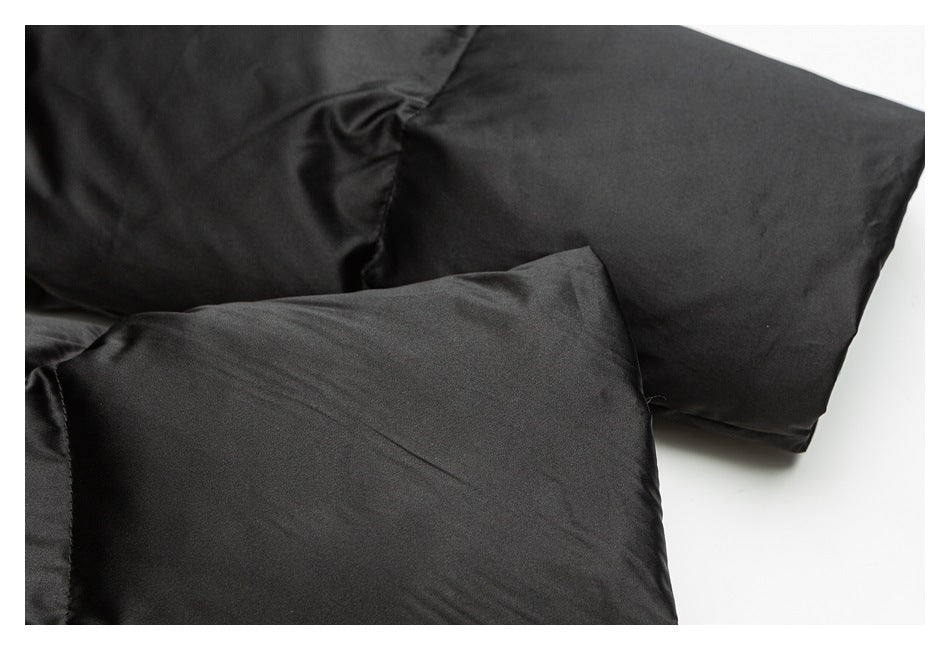 Close-up of overlapping black padded garment panels with stitched seams.