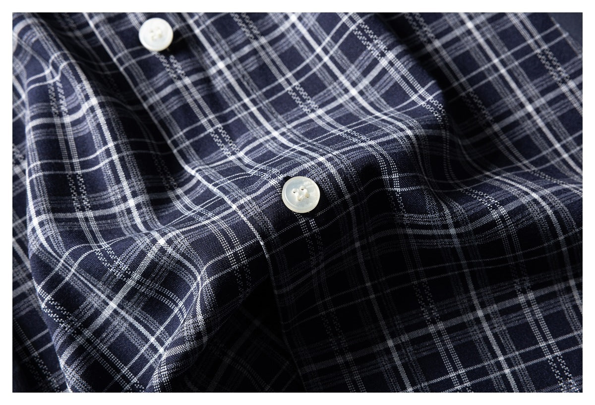 Close-up of navy-and-white plaid fabric with two light buttons.