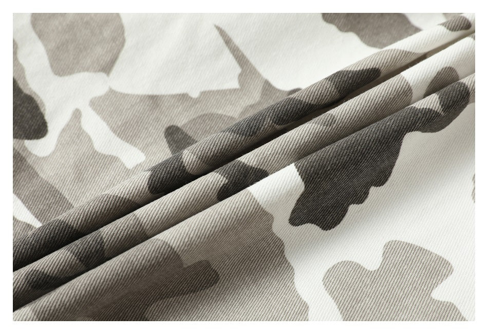 Close-up of the gray, taupe, and white camouflage fabric showing its diagonal weave and folded texture.