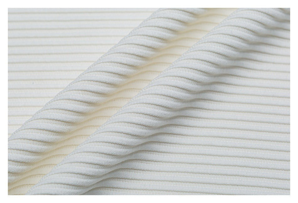 Close-up of white ribbed knit fabric folded in overlapping layers.