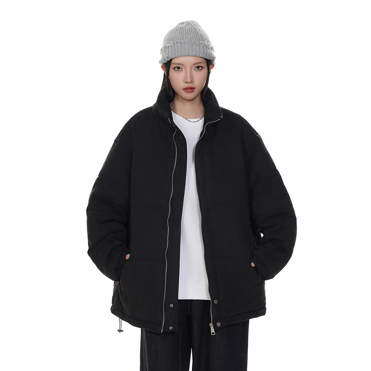 Model wearing an open black padded jacket with a high collar, front zipper and snap details.