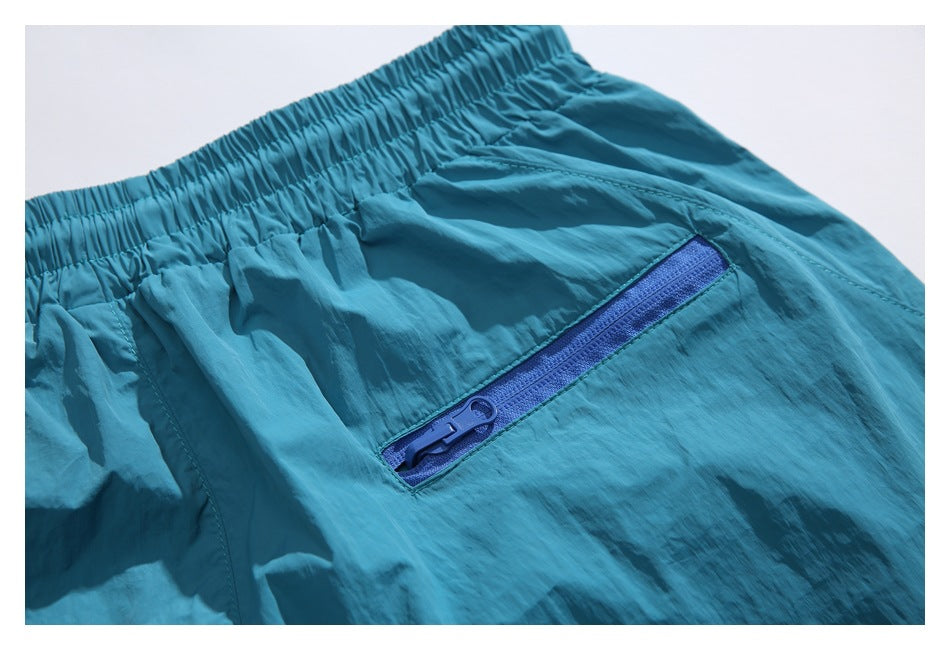 Close-up of the blue zippered pocket on teal shorts.