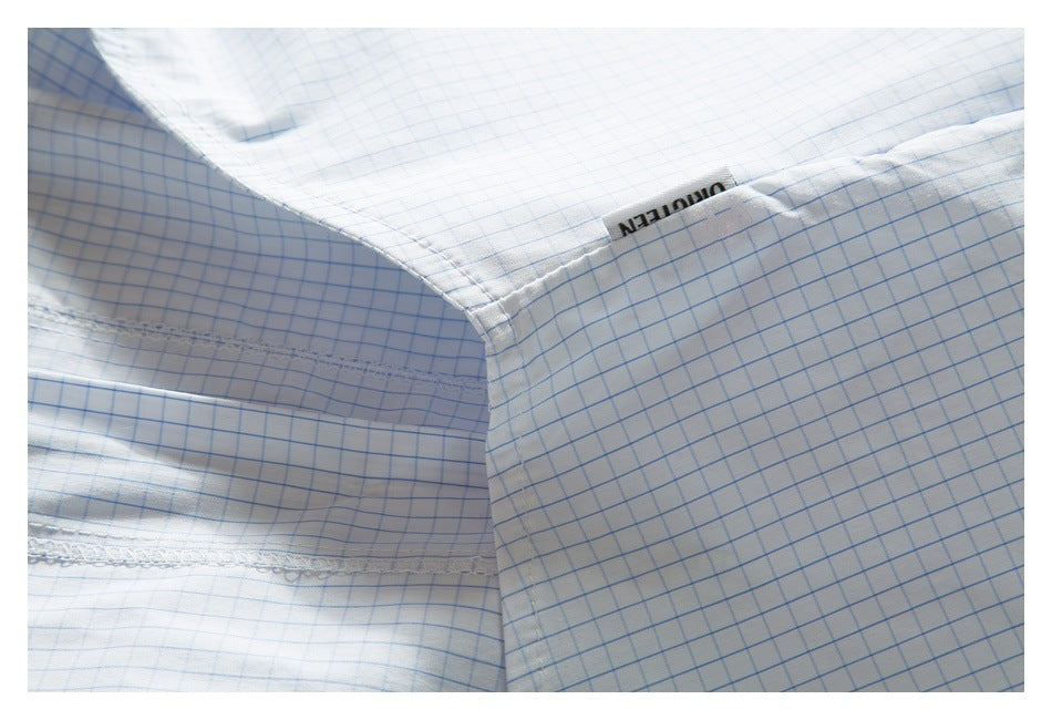 Inside seam detail of a white shirt with a light blue grid pattern and a small garment label.