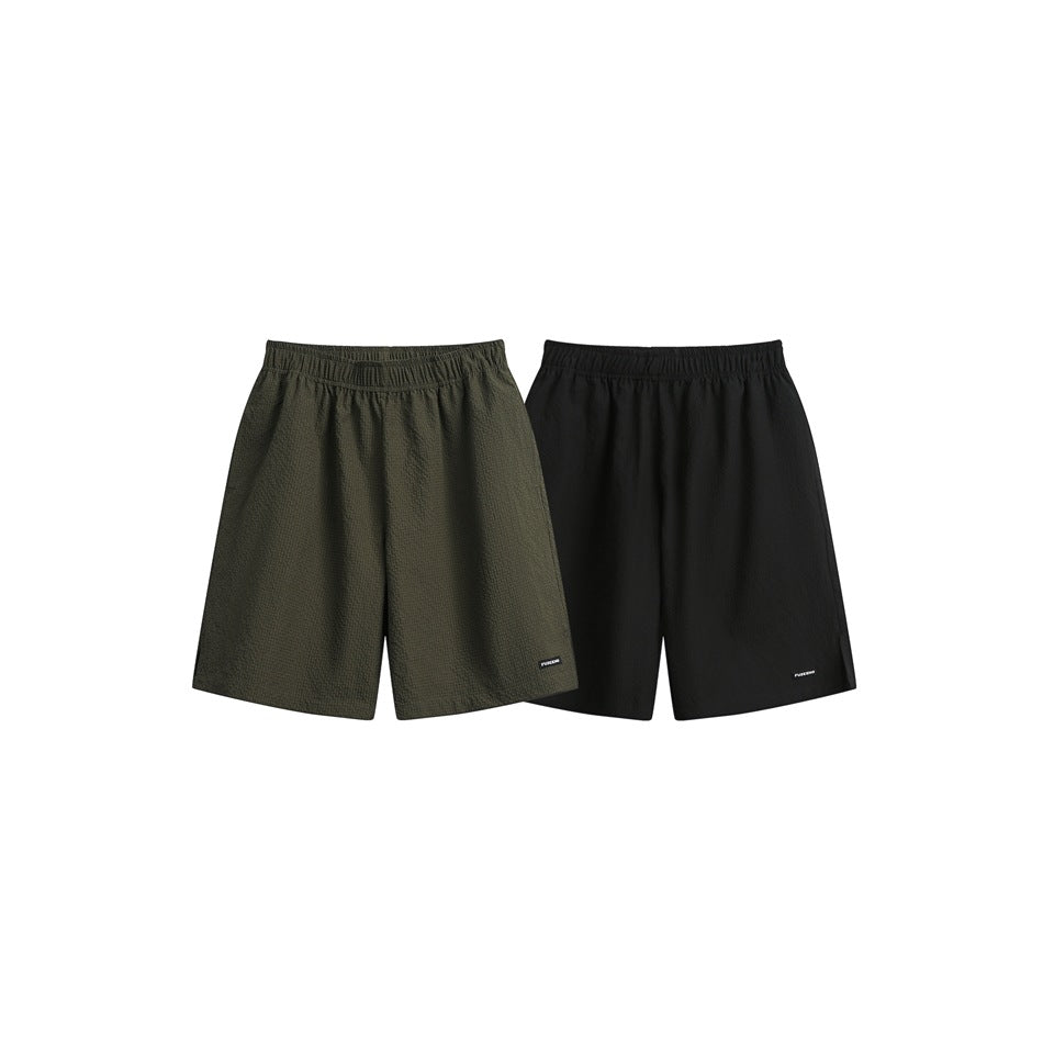 Two pairs of loose shorts shown flat: olive and black, each with an elastic waist and small hem label.