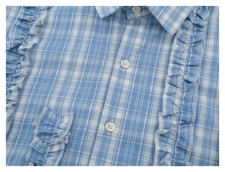 Close-up of a blue-and-white plaid shirt front with white buttons and ruffles along the placket.