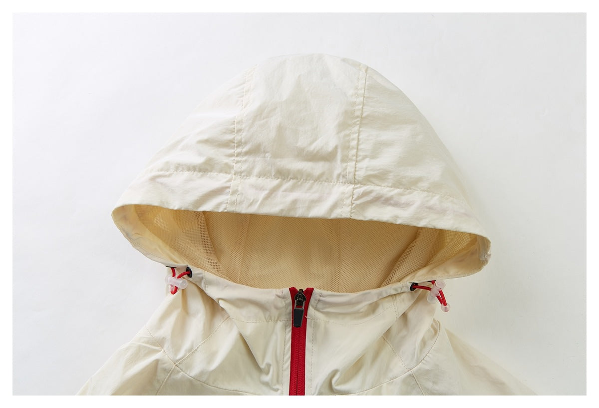 Close-up of a cream jacket hood with mesh lining, red drawcords and a red center zipper.