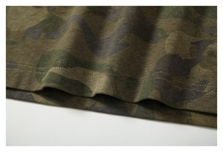 Close-up of a camouflage garment hem with visible double-row stitching.