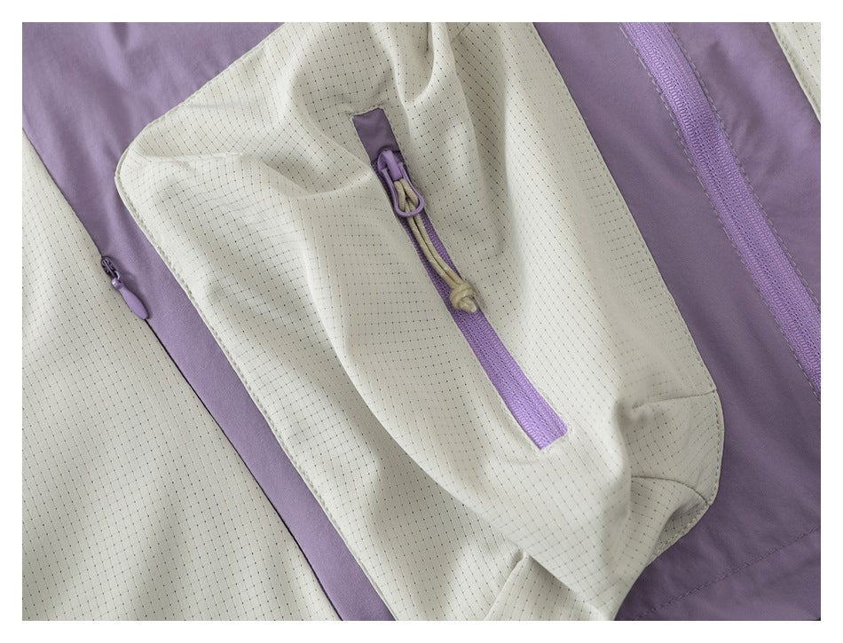 Close-up of a cream perforated jacket panel with a lavender zipper and drawcord pull.