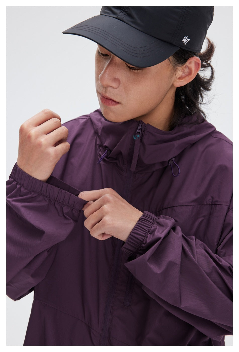 Close-up of the plum jacket’s hood, front zipper, and gathered elastic cuff.