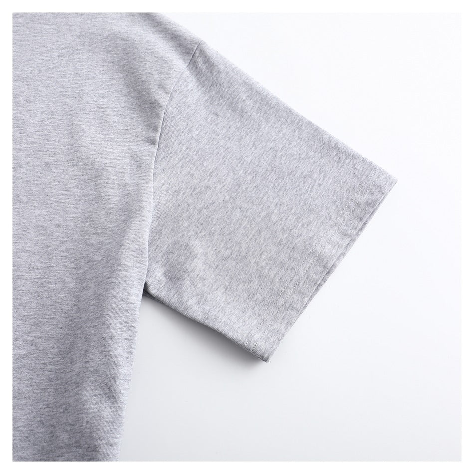 Close-up of a heather gray T-shirt sleeve and shoulder seam on a white background.