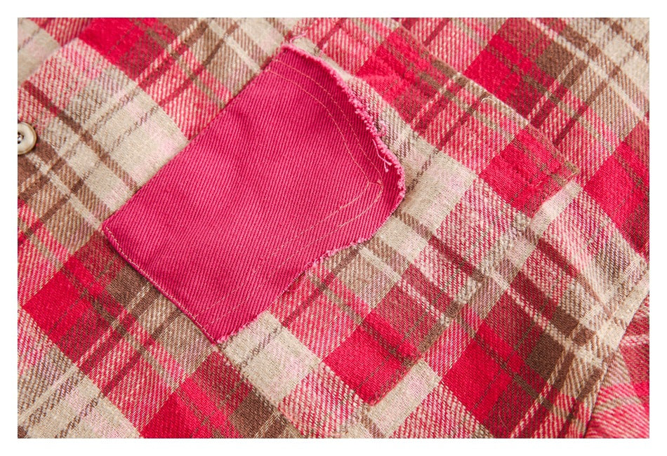 Close-up of a bright pink patch pocket on a red, cream, and brown plaid garment.