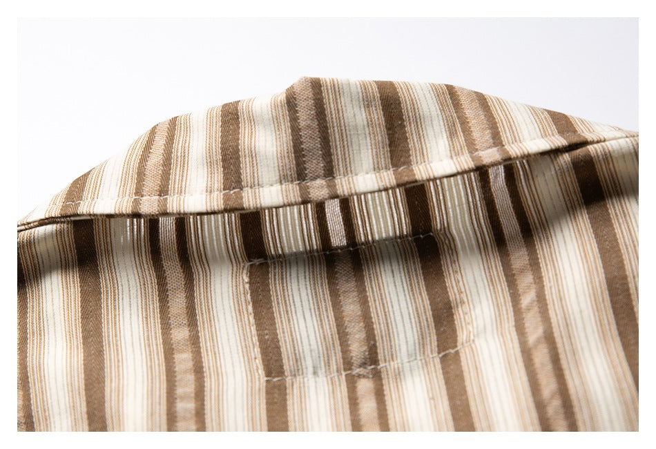 Close-up of a tan, brown, and cream vertically striped garment collar and stitching.