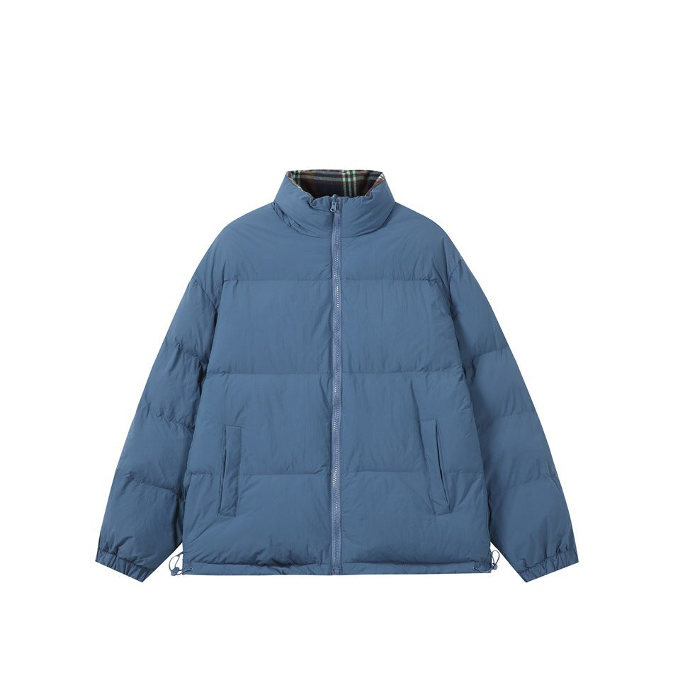 Blue quilted stand-collar jacket with front zipper, slanted pockets and plaid lining at the collar, flat lay