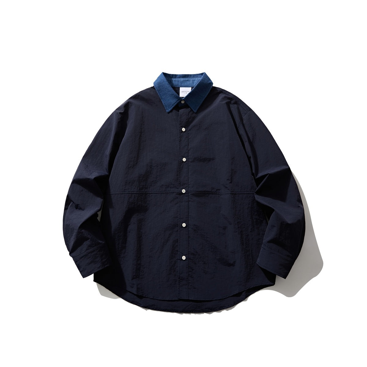 Navy button-up shirt with blue denim-look collar, flat lay front view with white buttons and a horizontal seam