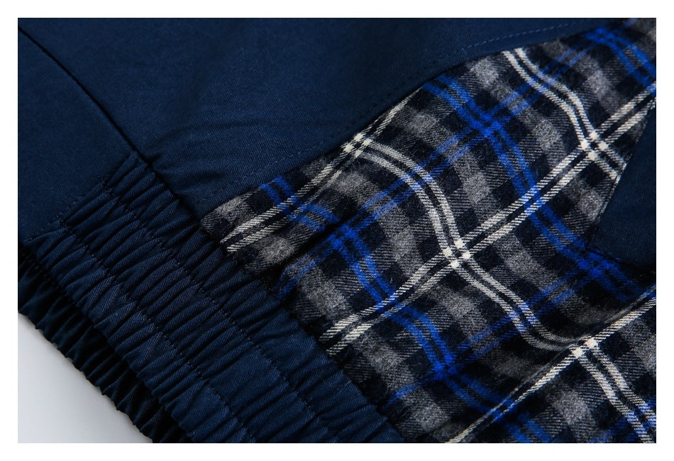 Close-up of a plaid jacket panel beside the gathered navy elastic hem.