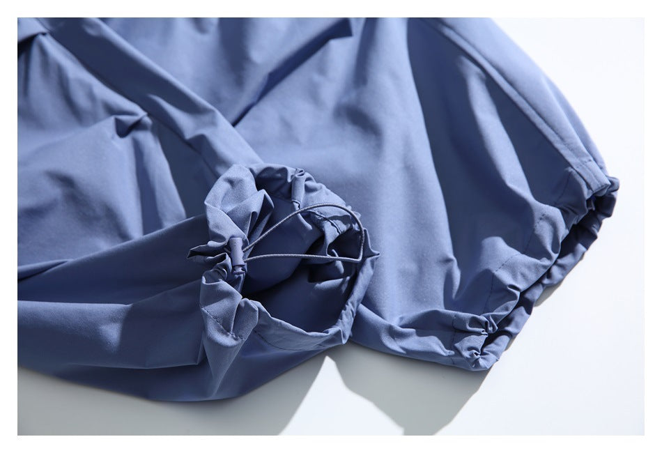 Blue garment detail showing a gathered opening with an adjustable drawcord.