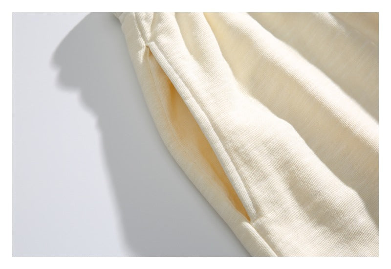 Close-up showing the side seam and pocket opening on the cream shorts.