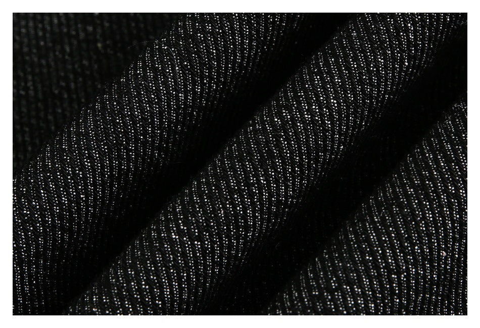 Macro view of black fabric gathered into folds, showing a fine reflective texture.