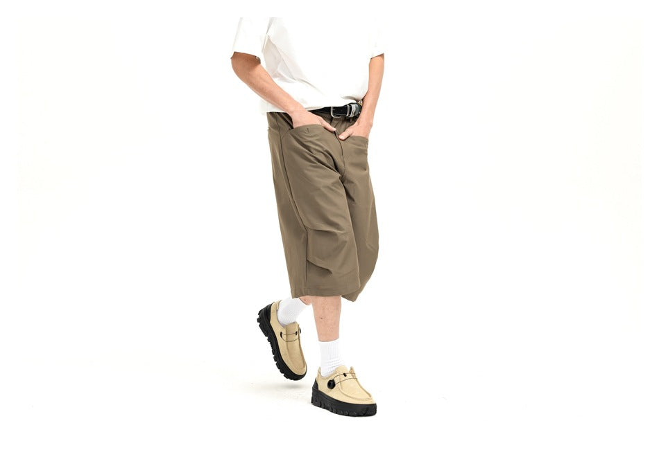 Angled view of olive-brown knee-length shorts on a model, showing a large flap cargo pocket.