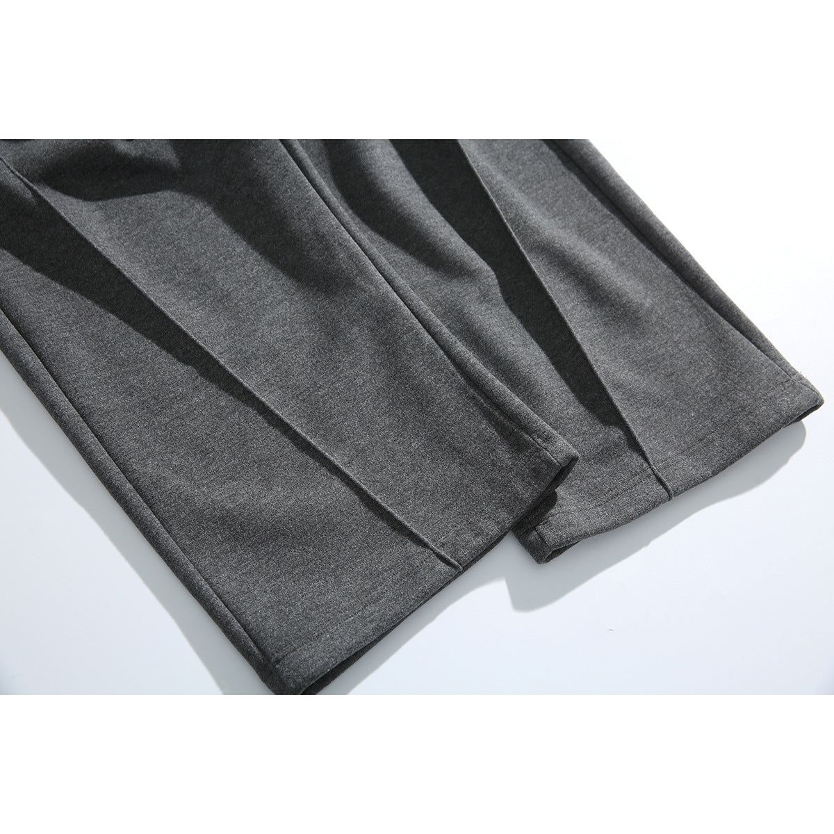 Close-up of the straight hems on charcoal pants.