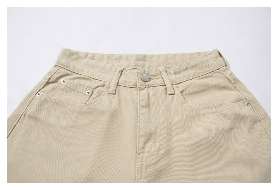 Front waistband and upper section of beige pants with belt loops, button, and pockets.