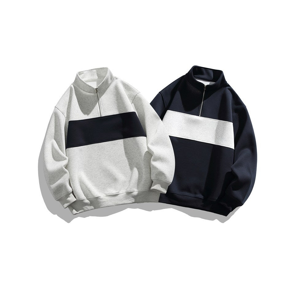 Two quarter-zip sweatshirts laid flat: light gray with a black chest stripe and black with a white stripe.
