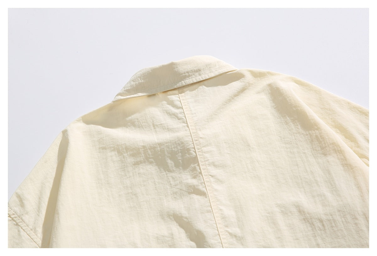 Cropped back view of an ivory collared shirt, showing the collar and center back seam.