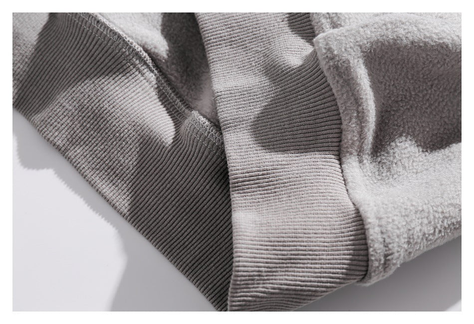 Close-up of a ribbed gray cuff joining the fleece sleeve fabric.