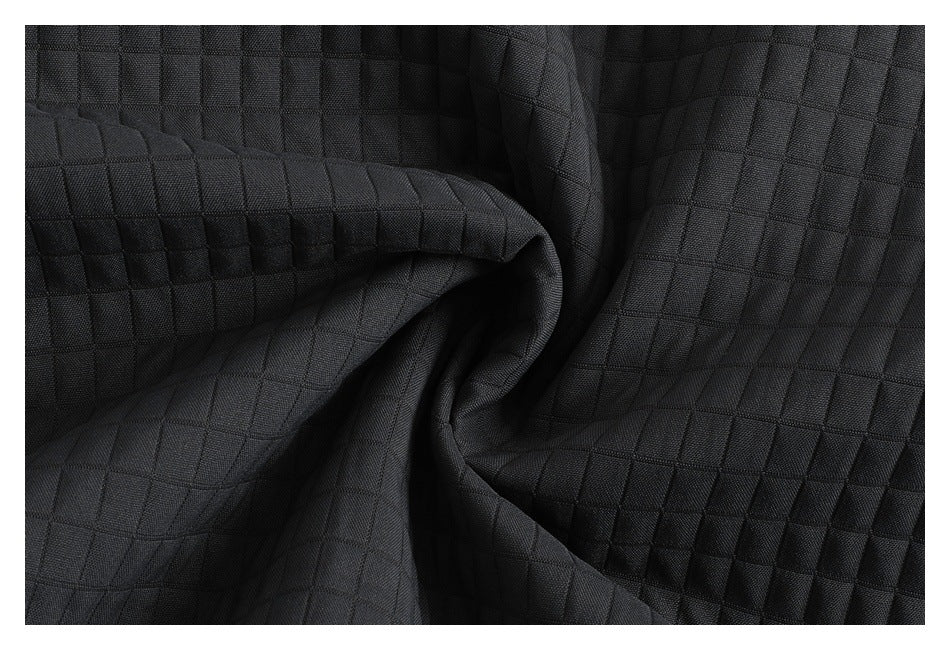 Macro view of the charcoal fabric's raised square quilting and folded texture.
