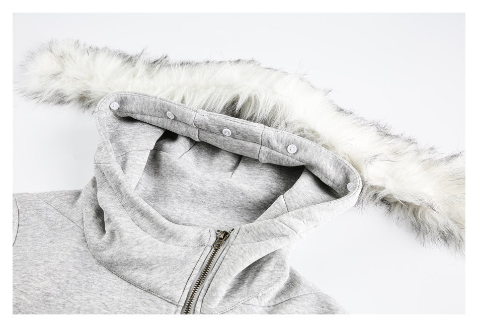 Close-up of a light gray hood with white fur trim, snap buttons, and a metal zipper.