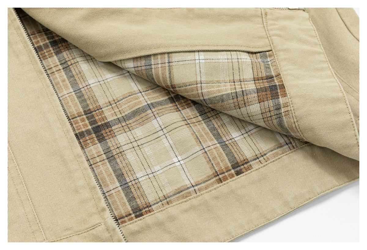 Close-up of a beige garment opened to show its tan, cream, and dark plaid lining and zipper edge.