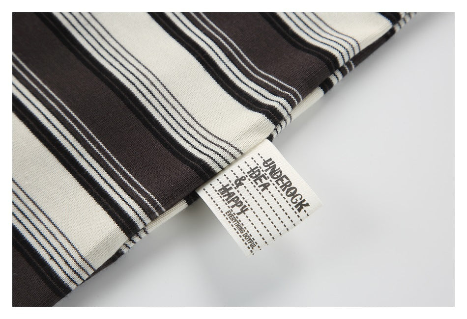 Close-up of a printed care label emerging from cream and dark brown striped knit fabric.