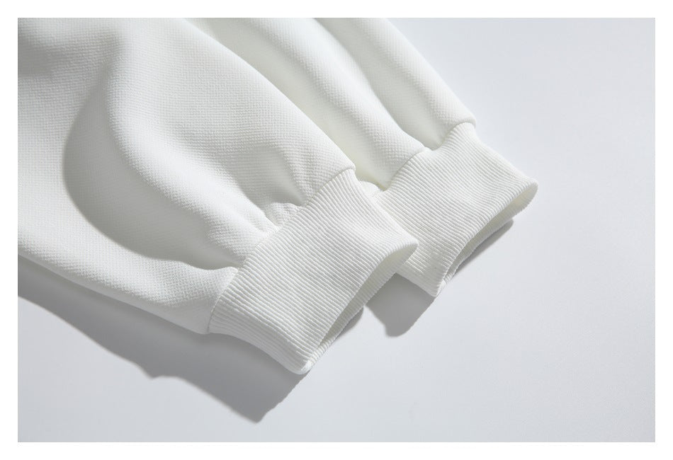 Close-up of two white ribbed cuffs on a garment laid flat.